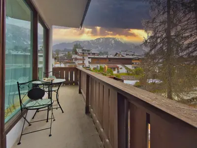 a balcony with a table and chairs and a view at Homeby, Dimora Sopiazes in Cortina dʼAmpezzo