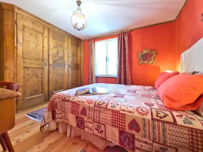 a bedroom with orange walls and a bed in a room at Homeby, Dimora Sopiazes in Cortina dʼAmpezzo