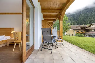 a balcony with chairs and a table and a bed at Residence Peter in Ortisei