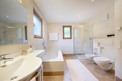 a bathroom with two sinks and a shower and a toilet at Residence Peter in Ortisei