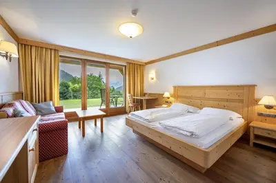 a bedroom with a large bed and a couch at Residence Peter in Ortisei