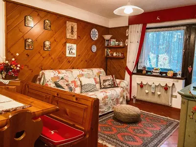 a living room with a bed and a wooden wall at Alloggio Il Cirmolo in Cavalese