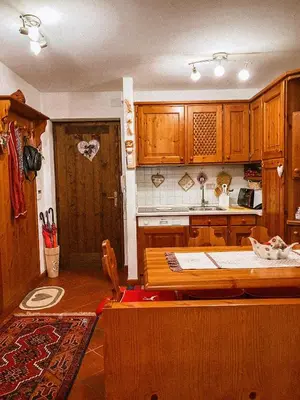 a kitchen with wooden cabinets and a wooden table at Alloggio Il Cirmolo in Cavalese