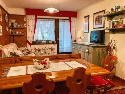 a living room with a table and a couch at Alloggio Il Cirmolo in Cavalese