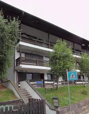 a building with a sign in front of it at Alloggio Il Cirmolo in Cavalese