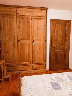 a bedroom with two wooden cabinets and a bed at Alloggio Il Cirmolo in Cavalese