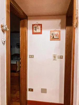 an open door with two pictures on the wall at Alloggio Il Cirmolo in Cavalese