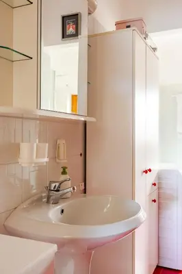 a white bathroom with a sink and a mirror at Casa dei Vessi il cuore di Fondo in Fondo