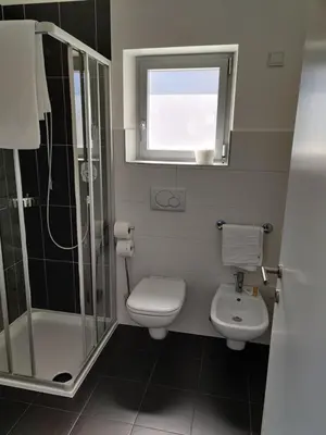 a bathroom with a toilet and a shower and a sink at GARNI MARIA Appartement in Varna