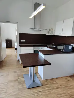 a kitchen with white cabinets and a wooden counter top at GARNI MARIA Appartement in Varna