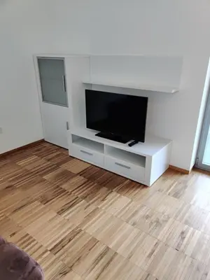 a living room with a flat screen tv on a white entertainment center at GARNI MARIA Appartement in Varna