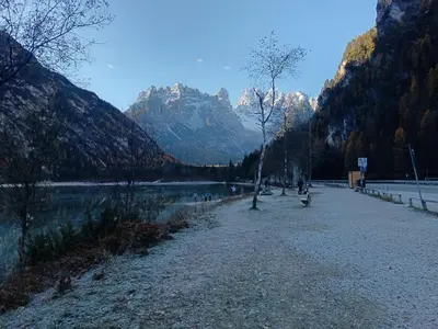 a park with a lake and mountains in the background at Aparthotel Carbonin in Dobbiaco
