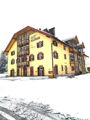 a large yellow building in the snow at Aparthotel Carbonin in Dobbiaco