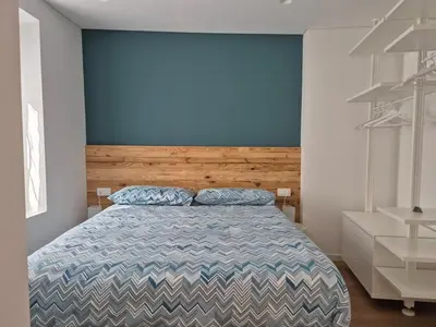 a bedroom with a bed and a blue wall at RosAlpina in Cavalese