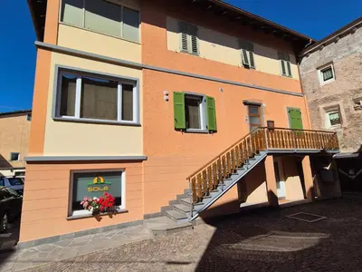 a building with a staircase and a window with flowers at RosAlpina in Cavalese