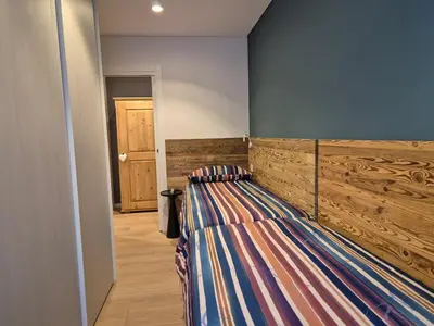 a bedroom with a bed with a wooden headboard at RosAlpina in Cavalese