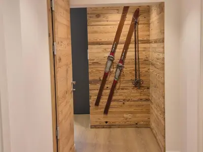 a room with a wooden wall with skis on it at RosAlpina in Cavalese