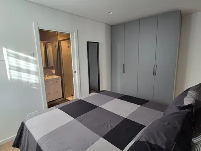 a bedroom with a black and white bed and a bathroom at RosAlpina in Cavalese