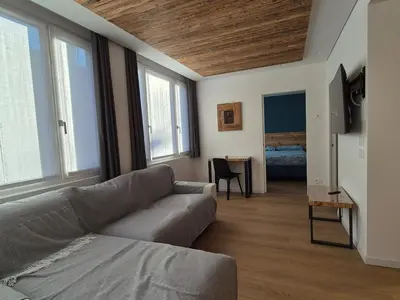 a living room with a couch and some windows at RosAlpina in Cavalese