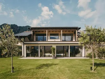 a house with large windows and a yard at Luna apartments in Terlano