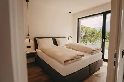a bedroom with a bed with a large window at Luna apartments in Terlano