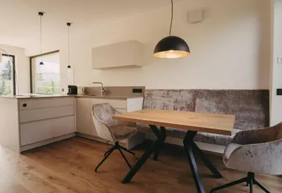 a kitchen with a wooden table and two chairs at Luna apartments in Terlano