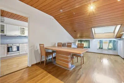 a kitchen and dining room with a wooden ceiling at City Center Penthouse Bolzano in Bolzano