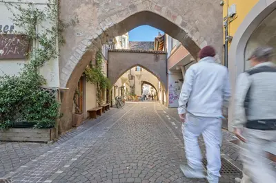 two men walking down a street in an alley at City Center Penthouse Bolzano in Bolzano