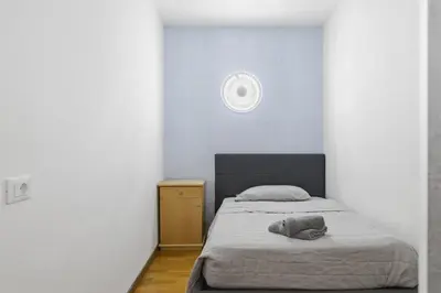 a bedroom with a bed and a clock on the wall at City Center Penthouse Bolzano in Bolzano