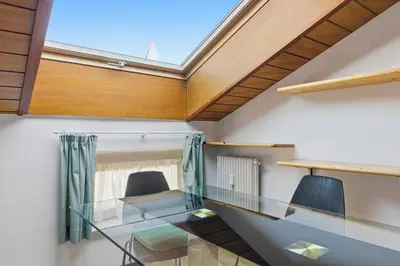 an office with a glass desk and a skylight at City Center Penthouse Bolzano in Bolzano