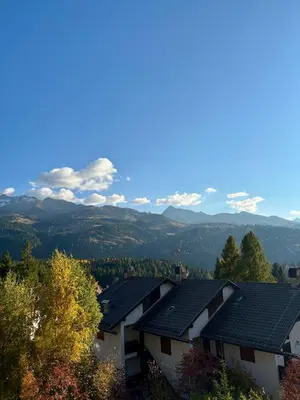 a row of houses with mountains in the background at Pragma Apartments - Sky Lodge Bellamonte in Bellamonte