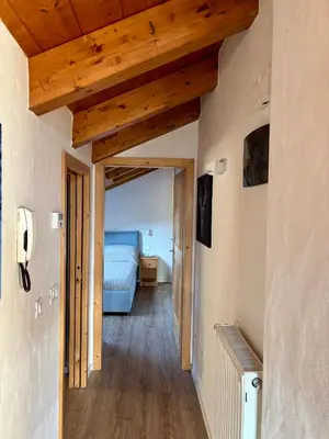 a hallway with a bed in a room with wooden ceilings at Pragma Apartments - Sky Lodge Bellamonte in Bellamonte