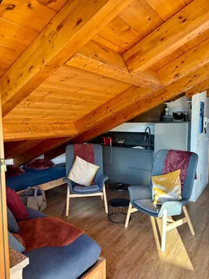 a living room with wooden ceilings and chairs at Pragma Apartments - Sky Lodge Bellamonte in Bellamonte