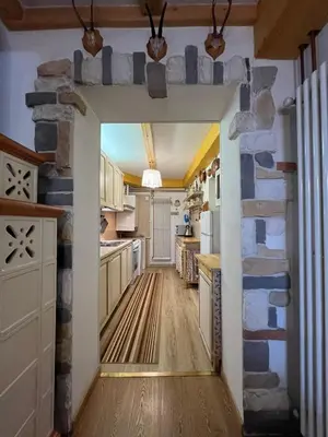 a kitchen with a stone wall and a doorway at Casa Gabry by Sunhome Fiemme in Varena