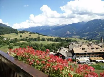 a view of a town with flowers on a balcony at Casa Gabry by Sunhome Fiemme in Varena