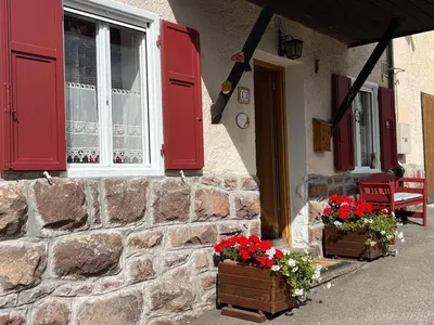 a house with red shutters and flowers on the porch at Casa Gabry by Sunhome Fiemme in Varena