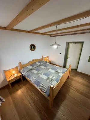 a bedroom with a wooden bed in a room at Casa Gabry by Sunhome Fiemme in Varena