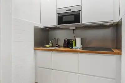 a kitchen with white cabinets and a microwave at Lauben Apartment II Bolzano in Bolzano