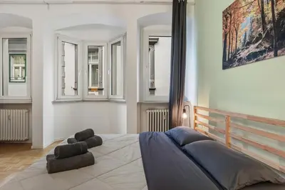 a bedroom with a bed in a room with windows at Lauben Apartment II Bolzano in Bolzano