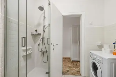 a bathroom with a shower and a washing machine at Lauben Apartment II Bolzano in Bolzano