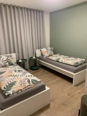 a room with two beds and two side tables at Ferienhaus Karin in Cortaccia