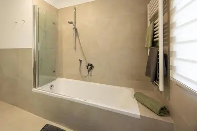 a bathroom with a bath tub with a shower at Ferienhaus Karin in Cortaccia