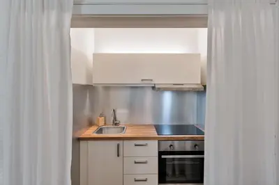 a kitchen with white cabinets and a sink at Lauben Balcony Bolzano in Bolzano