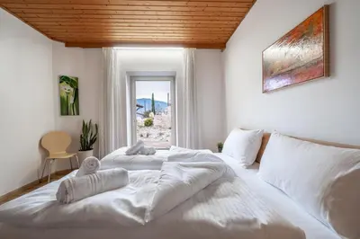 a bedroom with two white beds and a window at Apartments Palma in Cortaccia
