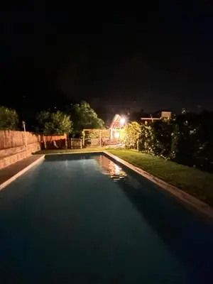 a swimming pool at night with the lights on at Apartments Palma in Cortaccia
