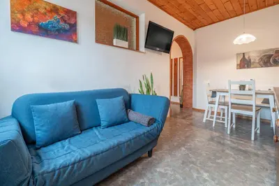 a living room with a blue couch and a table at Apartments Palma in Cortaccia