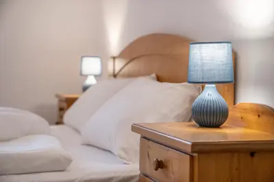 a bedroom with a bed with a lamp on a night stand at Apartments Palma in Cortaccia