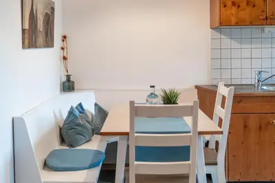 a small kitchen with a table and chairs at Apartments Palma in Cortaccia
