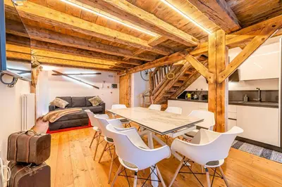 a dining room with a glass table and white chairs at Un Sogno Tra Le Dolomiti in Frena