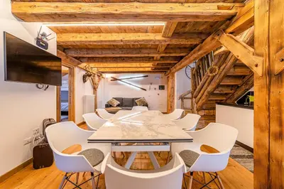 a kitchen and living room with a table and chairs at Un Sogno Tra Le Dolomiti in Frena
